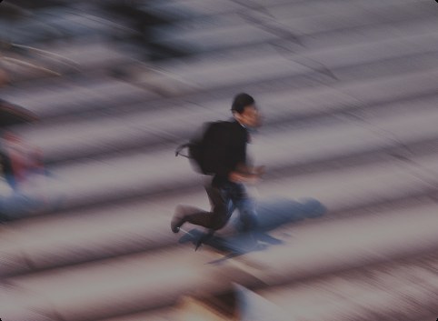 A figure running up a flight of steps, caught mid-stride in motion blur